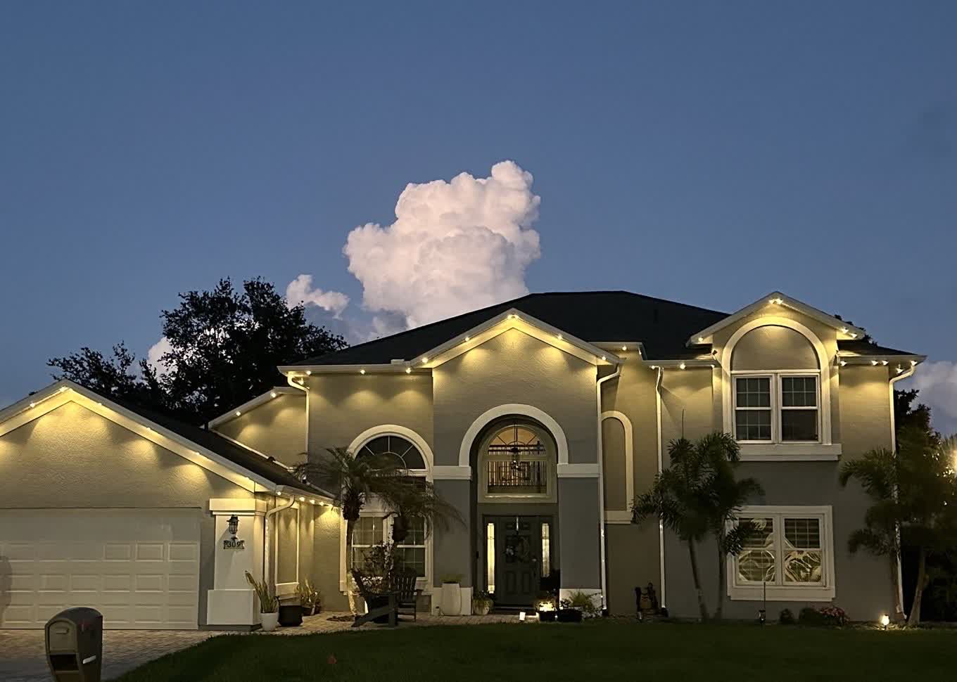 Warm white architectural accent lighting along rooflines and arches of a Melbourne FL home