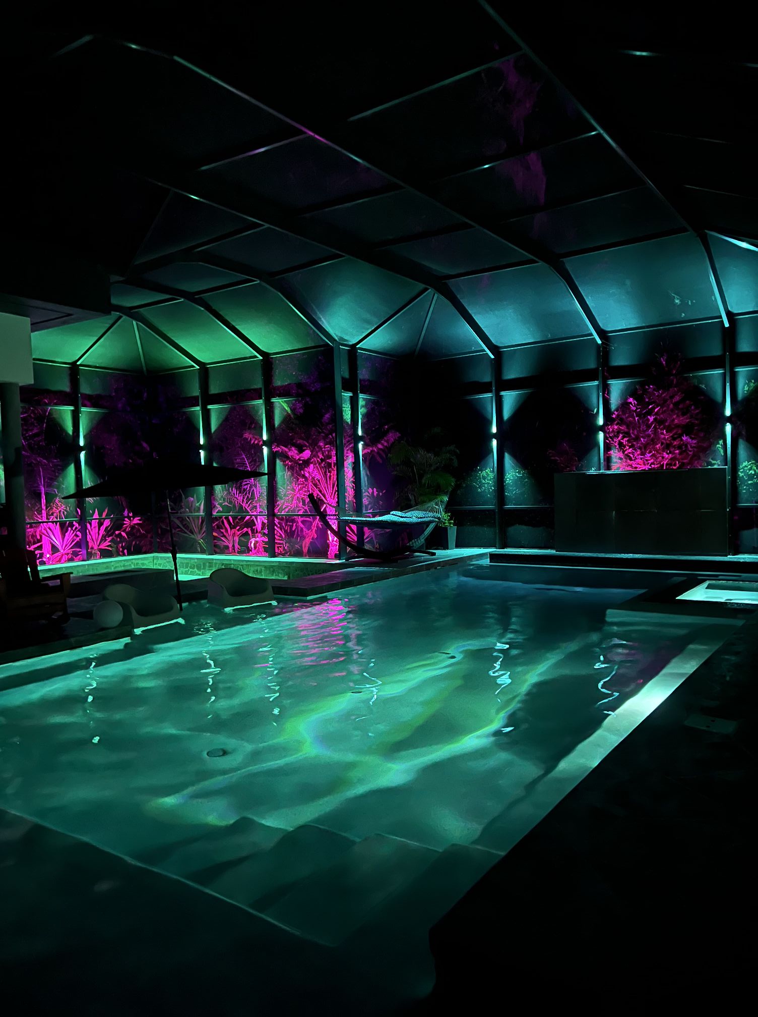 Pool cage and lanai permanent RGB lighting in green and pink, Melbourne Florida backyard oasis